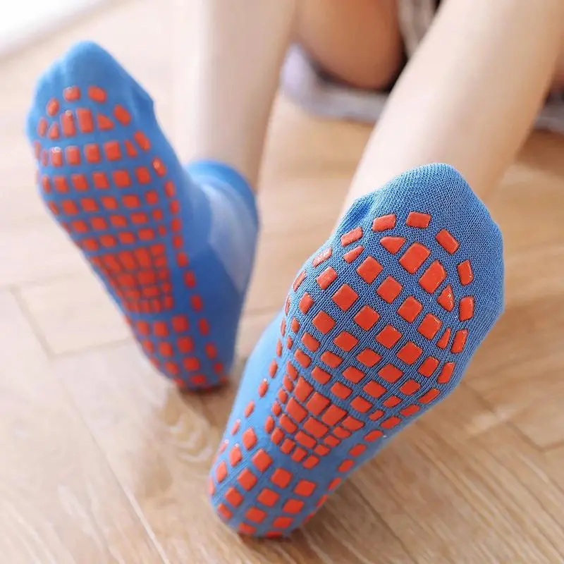 Close-up of blue non-slip grip socks with orange traction dots, ideal for home use and yoga practice.