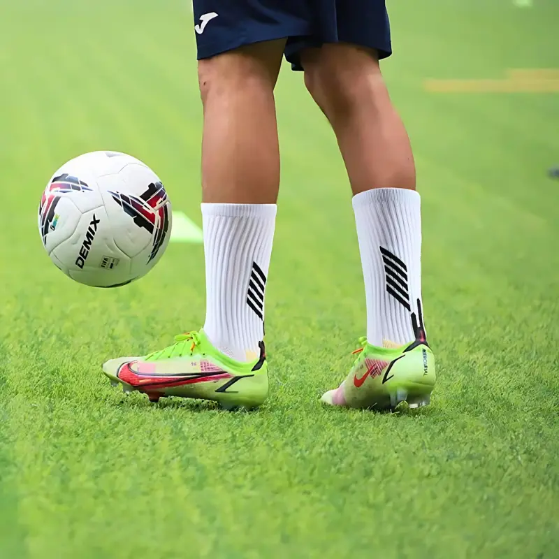 Soccer player wearing grip socks for enhanced traction and stability on the field during training.